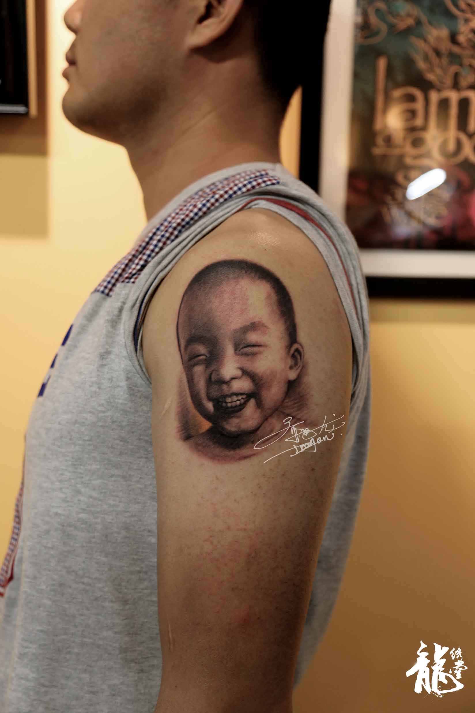 男人大臂外侧小孩人物黑灰素描肖像纹身