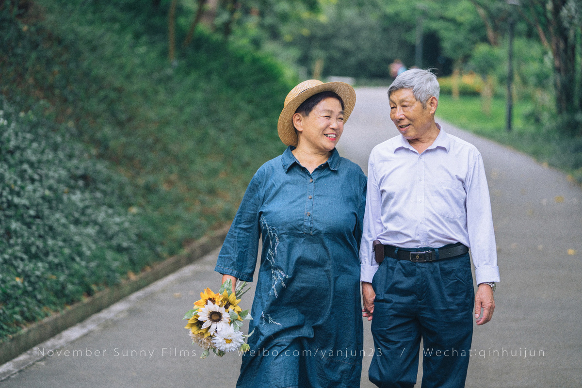 老年夫妻并肩在公园散步高清摄影大图-千库网