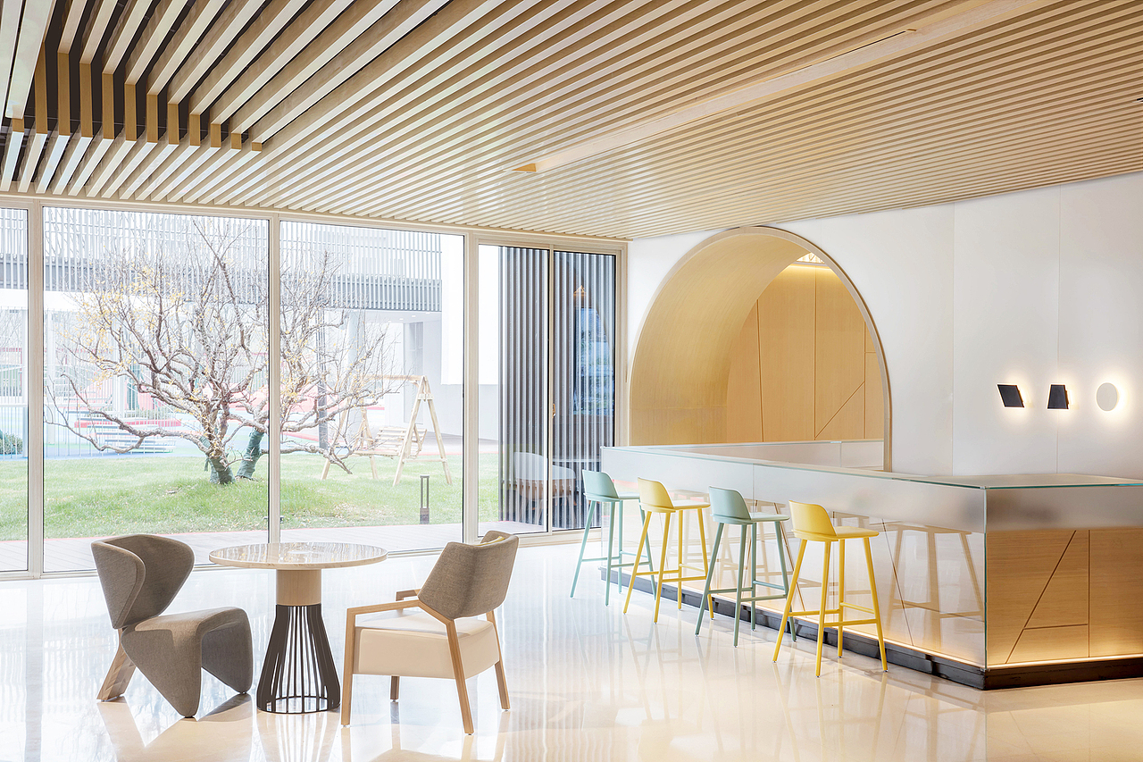 空间背景中彩色半透明布帘设计,源于对童年一家人在野外放风筝的温馨联想。风筝透明的羽翼飘在空中,有各式花色。户外光照透过布帘照进来,是不同颜色的光。