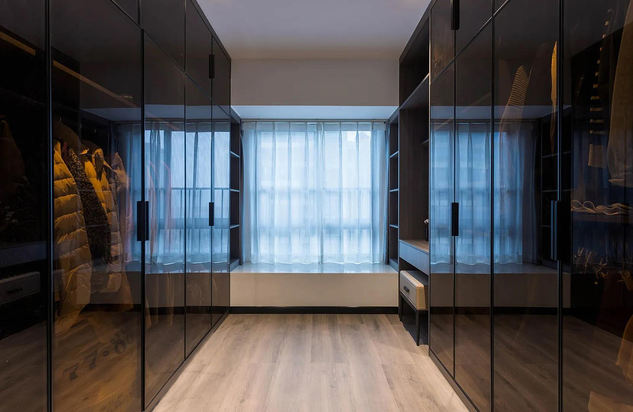 步入式衣帽间柜门材质采用的是透明玻璃,便于主人的选择。靠近窗户处留出化妆台的位置,分区合理,结构与美感并存。
<br>