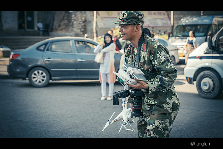 警车武警,都在周围维护治安,这个战士用无人机进行执勤