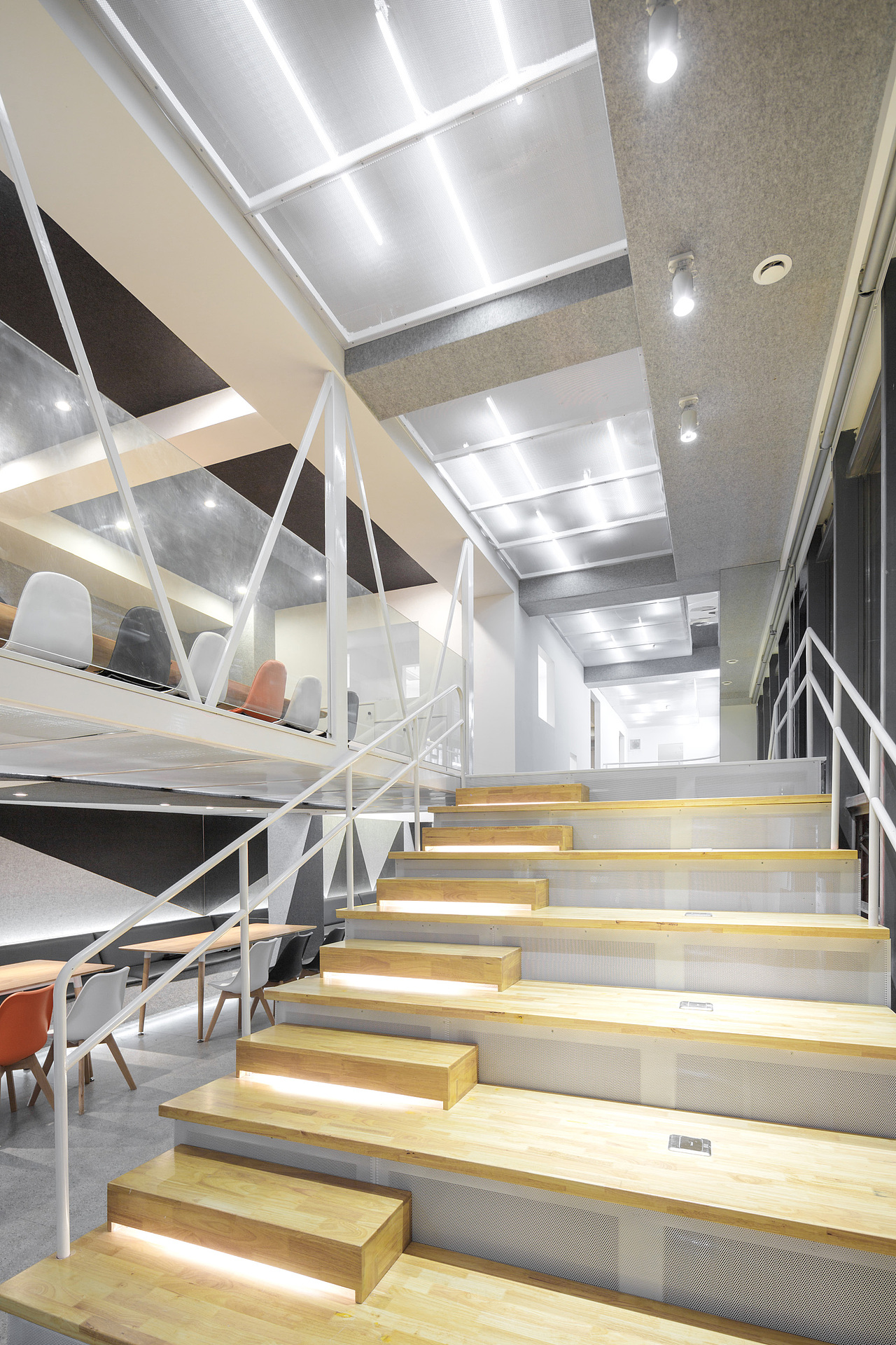 阶梯的置入一方面满足上下层交通需求,并且可以供客人休息欣赏窗外的景色,以及看电影,促进更多的交流和活动发生