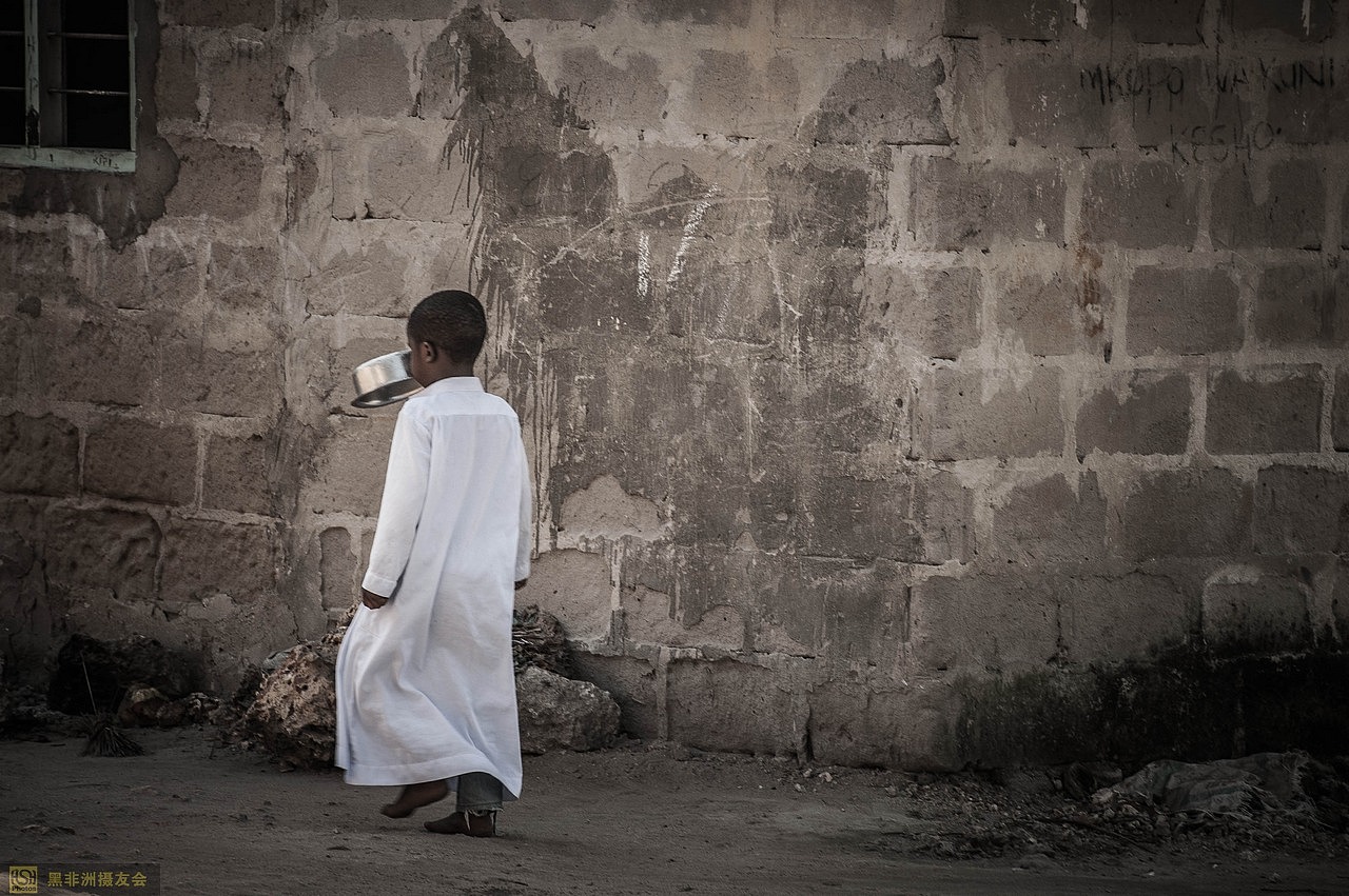 一个小孩叼着银色的盘走路。