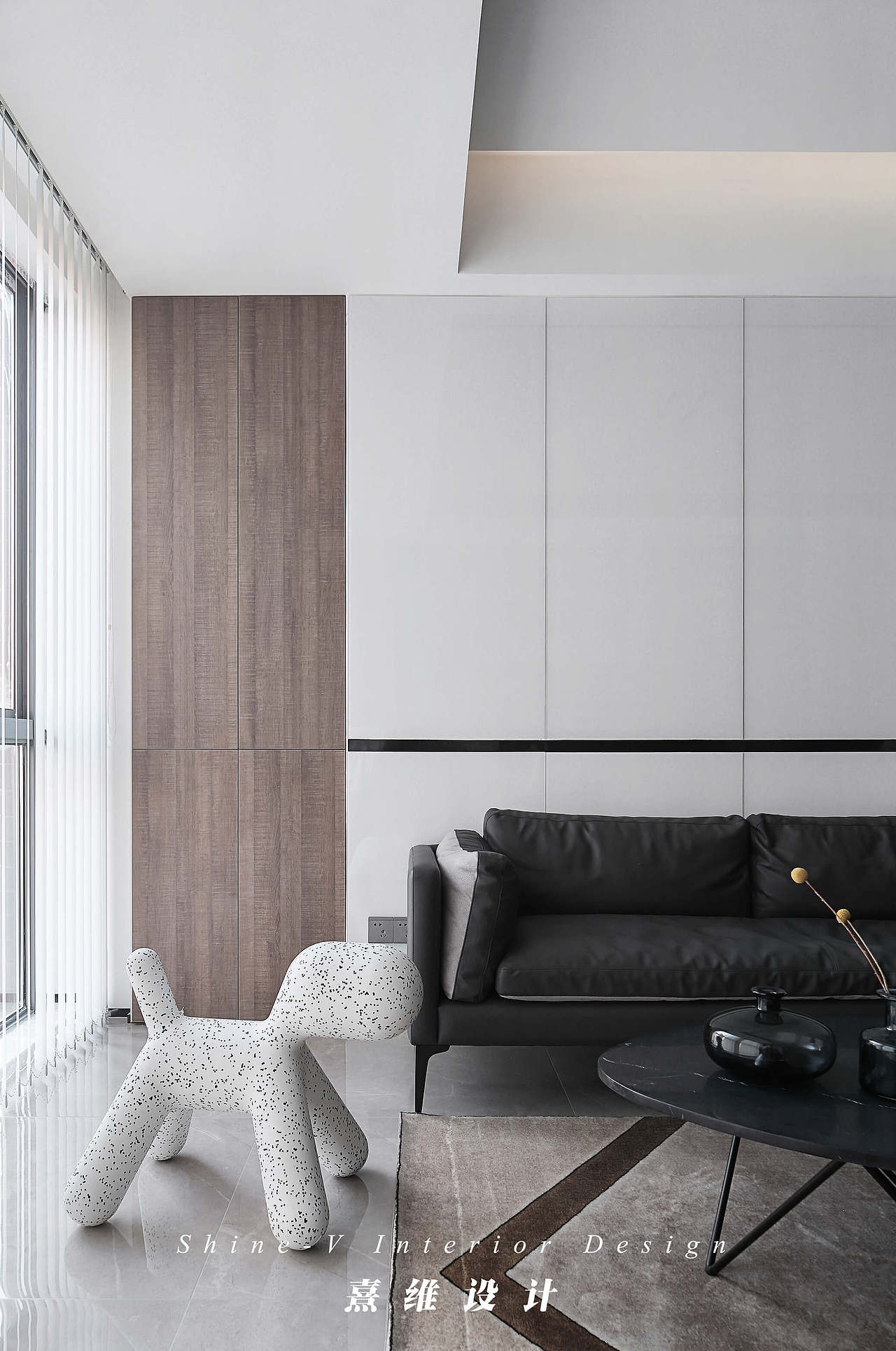 沙发背景墙是白色亮面饰面板,腰线处点缀黑色线条,是黑白交织的家中的