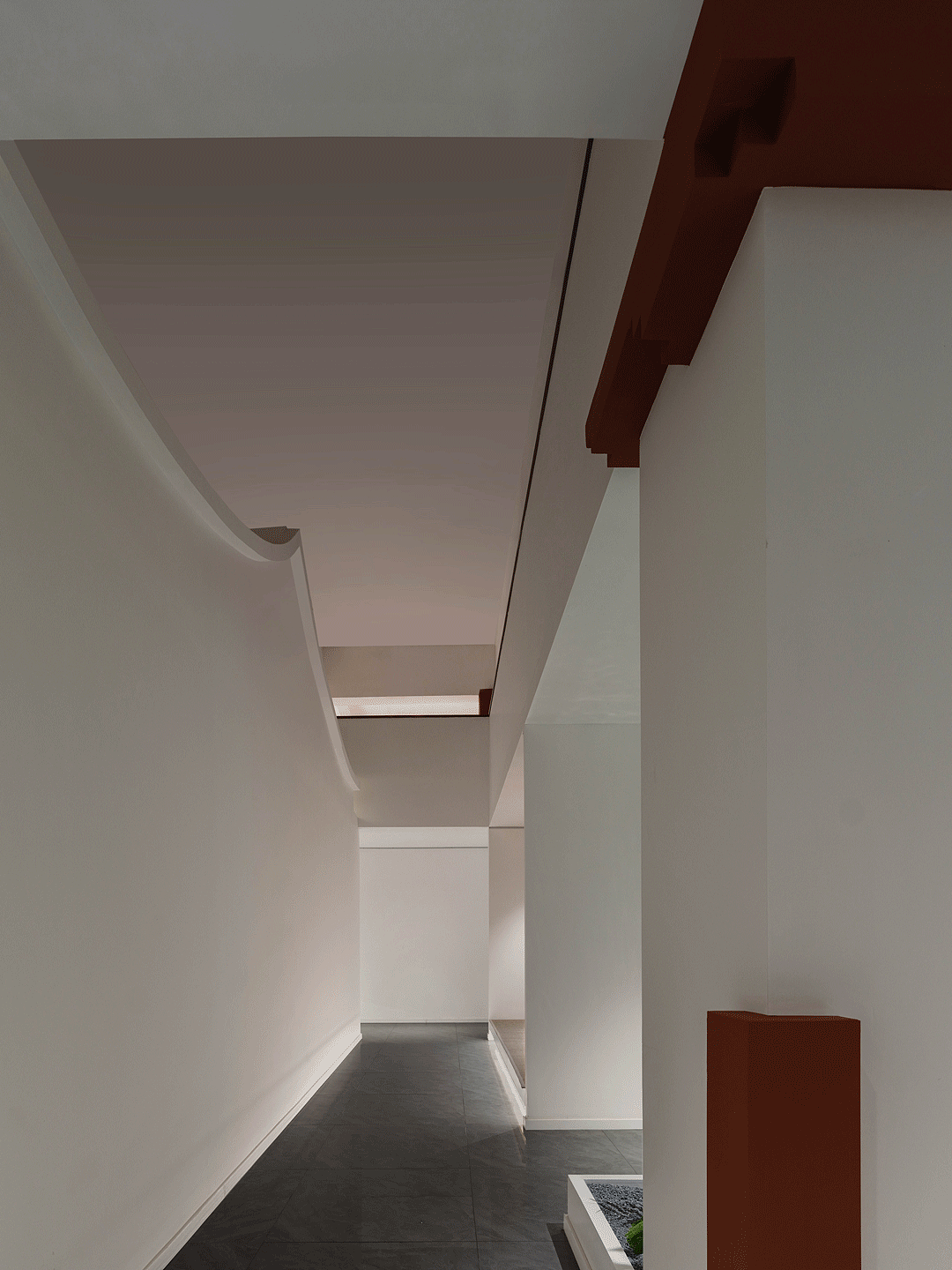 “素材之中,凝聚着人与素材的悠久历史。或许可以说,有关素材的记忆在人体积蓄”,红木家具的魅力与价值在便在于“材质”本身,加上其独特的榫卯工艺,“形、色、质”,每一个产品都是匠人与自然的结合。在设计中本着空间服务产品的出发点,整体营造以白色为主,以突出家具本身。赤红作为的跳色被用在主要的空间转折处作为点睛之笔。