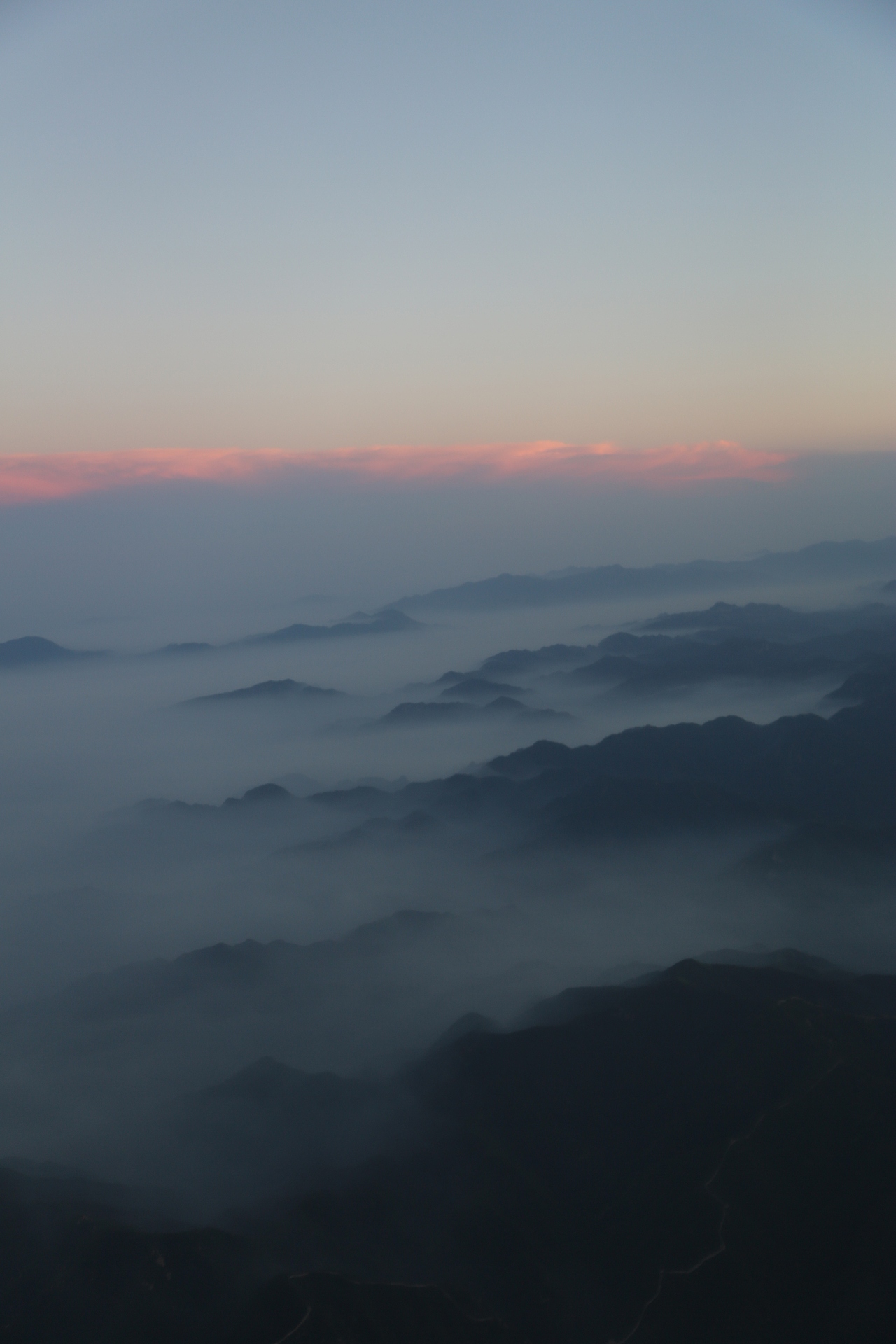 雾气缭绕在山腰,红色的日光在雾后更加温柔。