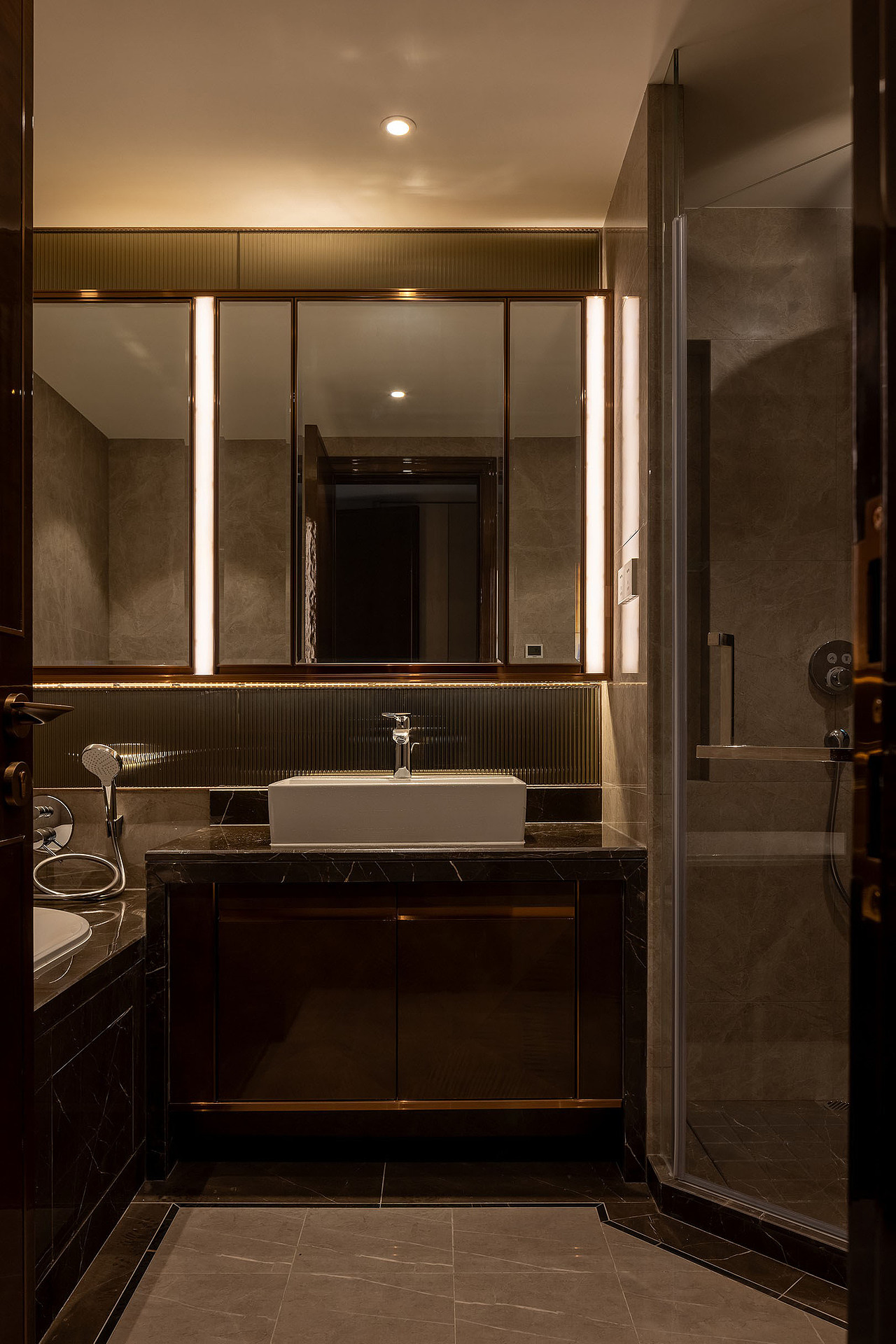 采用斜角切割的方式,实现干湿分离的需求,优化开关门的动态体验。沿结构轮廓勾勒复古的波导线,链接纹理质感与氛围感光效,借用镜面玻璃等材质的属性为空间营造灵动美感,阐述精奢之美。