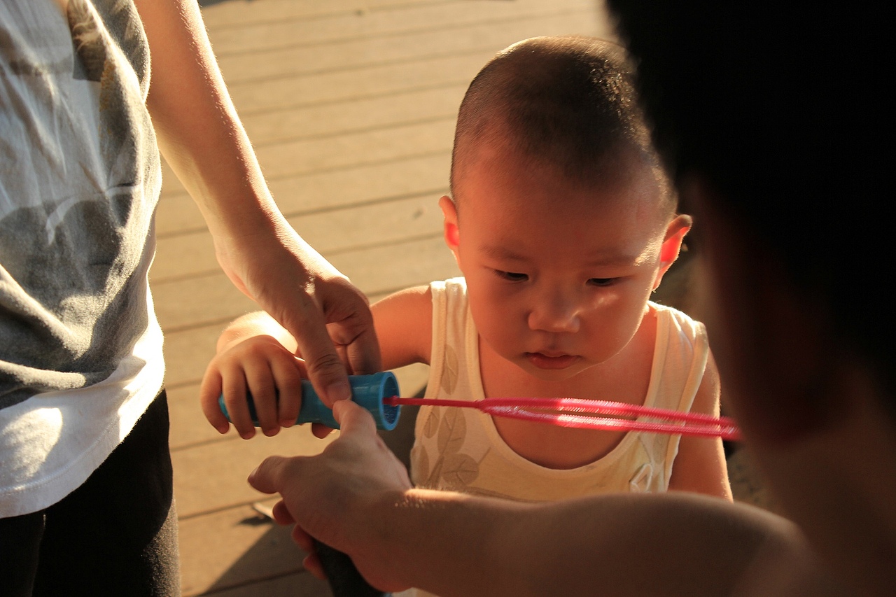 追着泡泡奔跑的小伙子,自己却不会吹,很逗