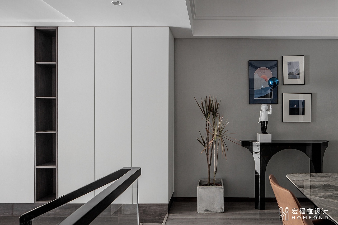 虽然为错层户型，但相差高度只有280mm，为了空间更具统一性，我们缩短了楼梯的宽度，设计为与电视墙联通的储物柜。顶部延续简洁的石膏线条呈现，在视觉上显得自然流畅。