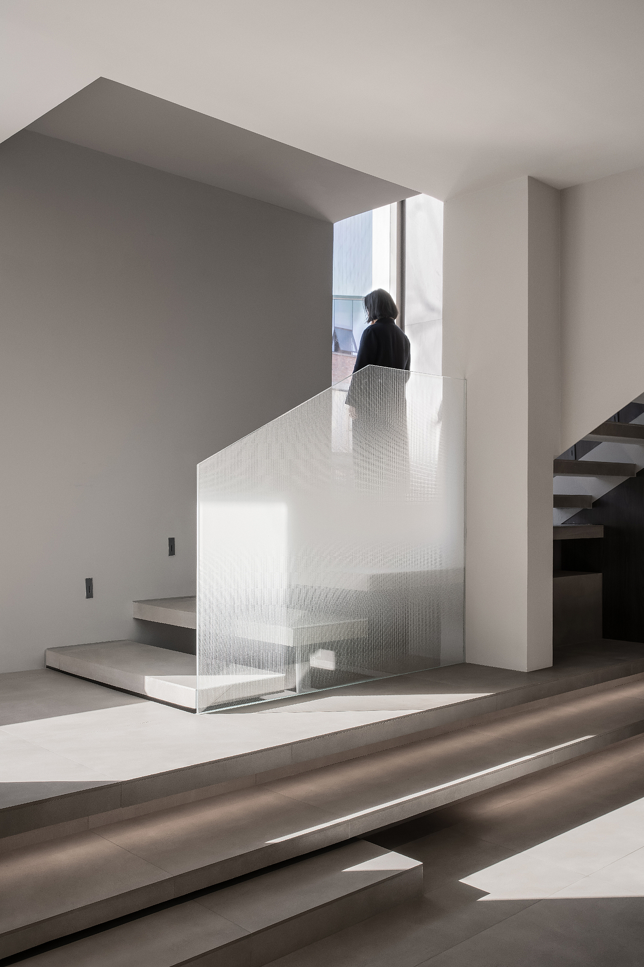 从入口处,经过一段狭长的走道后逐渐走入,此时需要下探几步才正式踏进豁然开朗的开放高挑的室内空间,若继续拾阶而上,可以直达二楼的会客茶室之中。