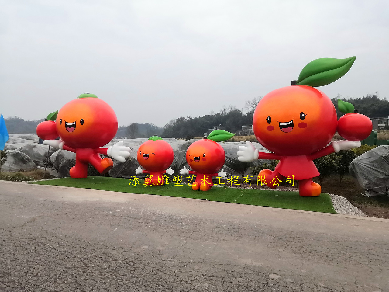 手捧橘色水果卡通雕塑摆件是果园招引旅客重要法宝之一