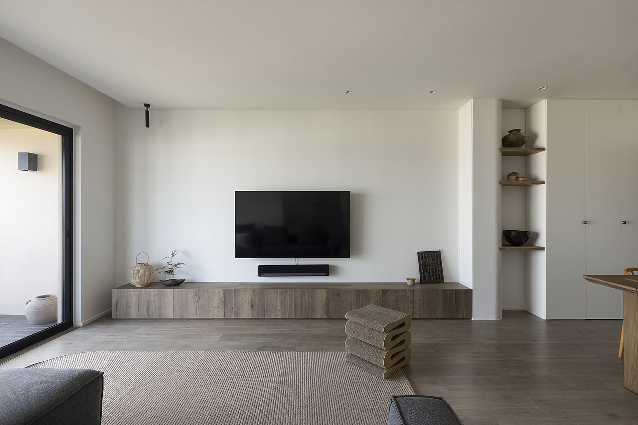 客厅与餐厅连接处做了一列350深带弧度的柜体，手作感的层板中和一旁工厂定制板的机械感。