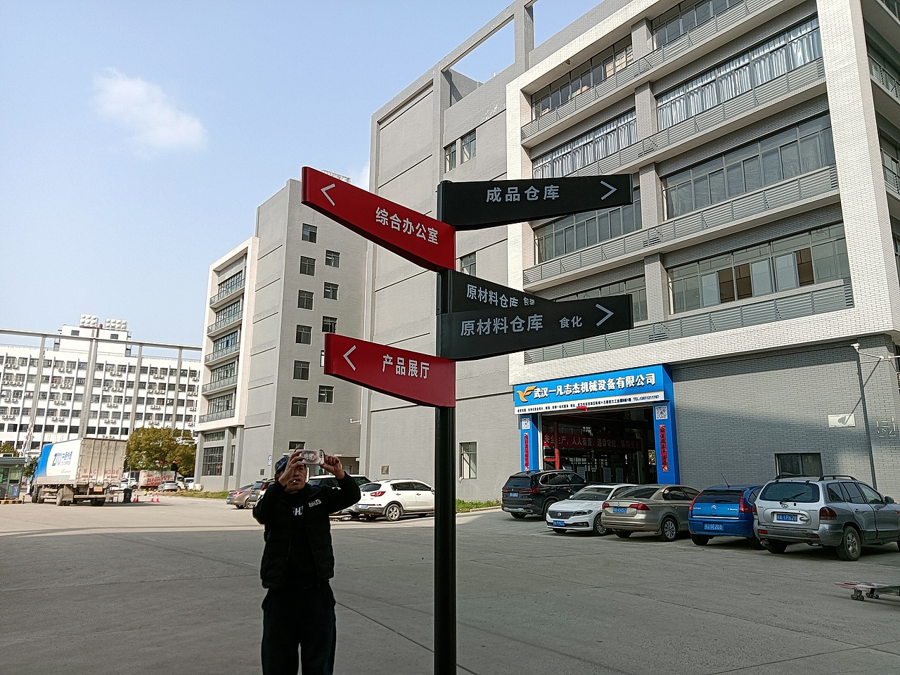 看,一个草根大叔正和道路指示牌摆pose