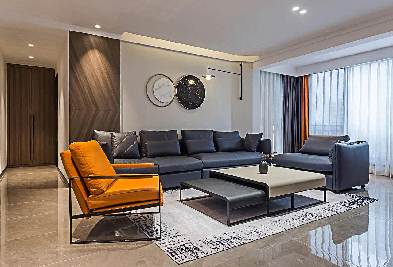 整个客厅以现代风的设计,浅灰的地砖上布置简约暖色地毯,电视墙是大理石面板材质、沙发墙是简单的白色墙面,结合深色调的皮沙发、黑白相加的端庄茶几与摆饰品,让空间显得格外的高级精致。无主灯设计让空间更加开阔,漫反射灯光的点缀让空间更加层次分明。