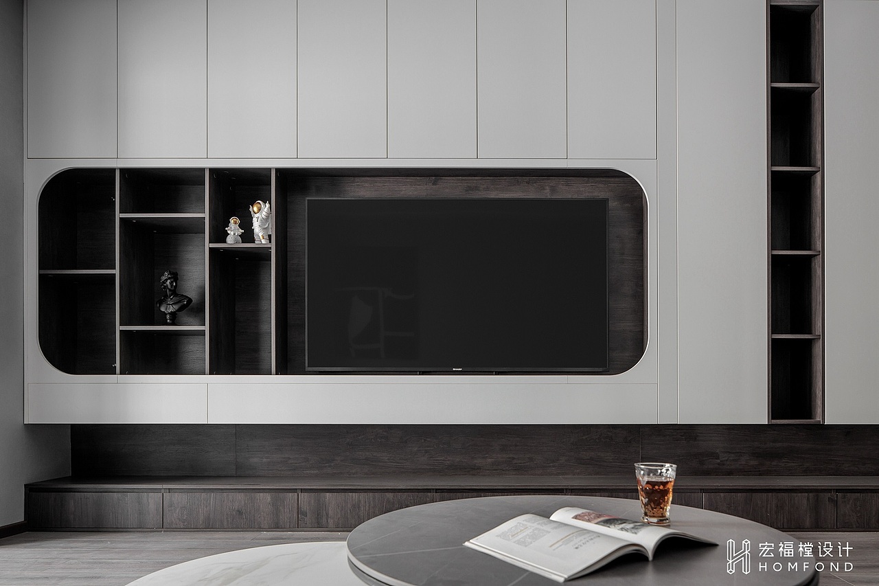 充分利用可用空间，将阳台改造为书房后，靠右侧设计为工作台使用。电视墙面也重点设计为更具功能性的储物柜+展示柜形式。但在规划形式时，打破了传统呆板的柜体造型，以不规则的多种几何图形呈现，在满足储物需求的同时也成为了空间中引入注意的独特装饰。