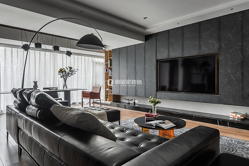 客厅整体以暗色调呈现,现代风格极具质感,黑色电视背景墙+黑色皮质沙发,让整个空间充满高级感。局部以亮色点缀,跳色单椅让空间灵活起来。
