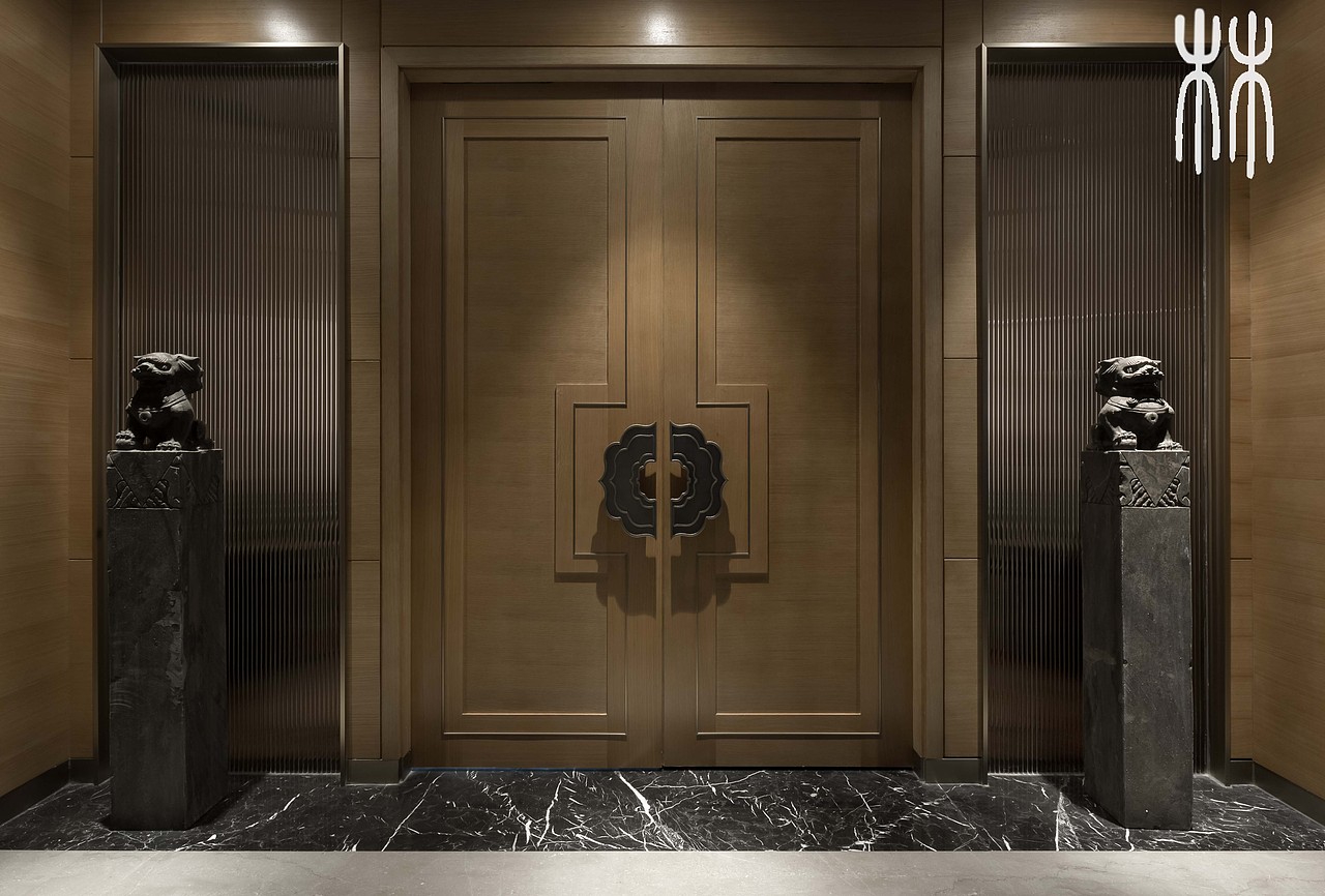 古铜中式花样拉手推开了仪式感强烈的双开大门,在大门两侧分别座落着