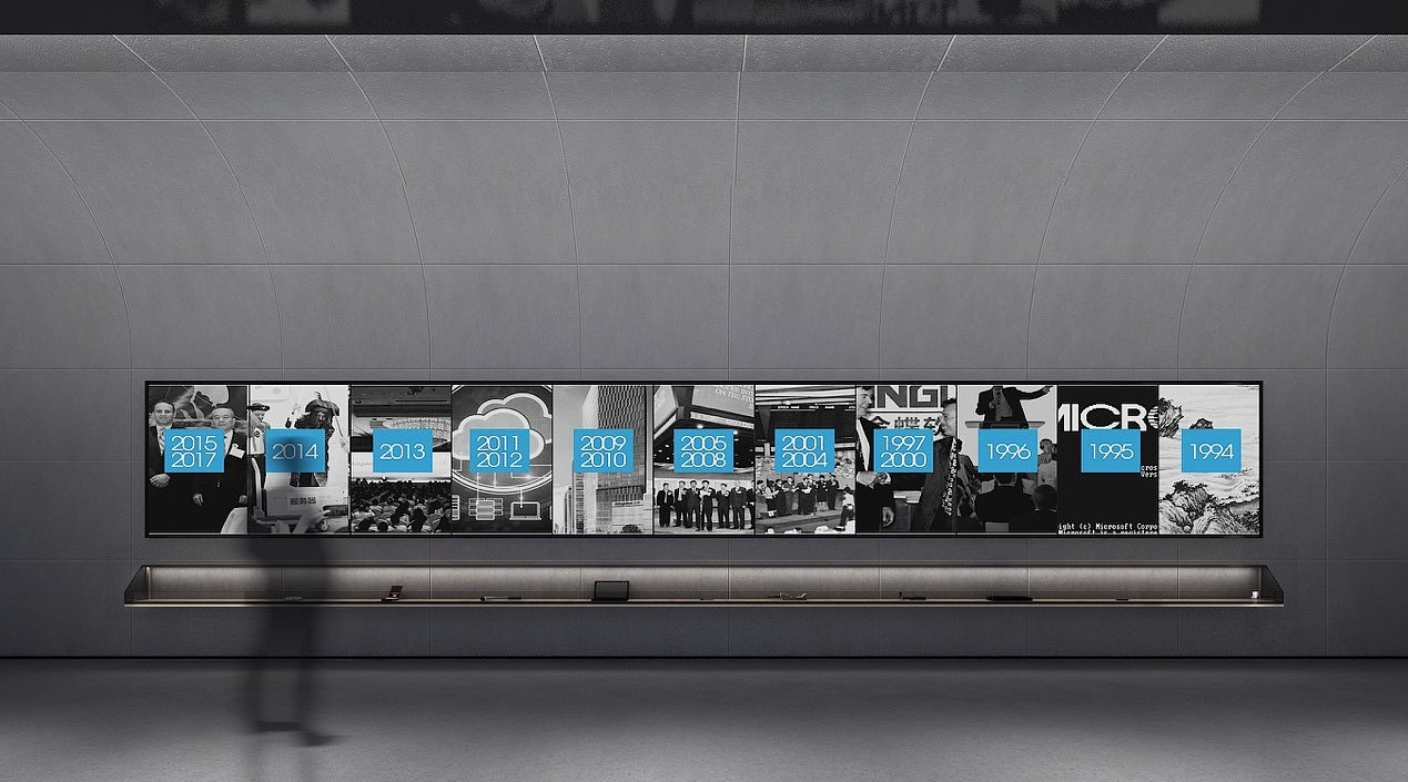 在参观末尾的是企业文化与荣誉展区,展厅风格由前段的空灵通透过渡到扎实沉稳。深灰色的石料通过曲折与分割,展现一段属于金蝶荣誉的史诗。参观者走在这一段展区,阅读着墙上的数字与图片,会不自觉地被这种厚重的力量所感染,心中沉淀出对金蝶品牌更深刻的认知与感受。