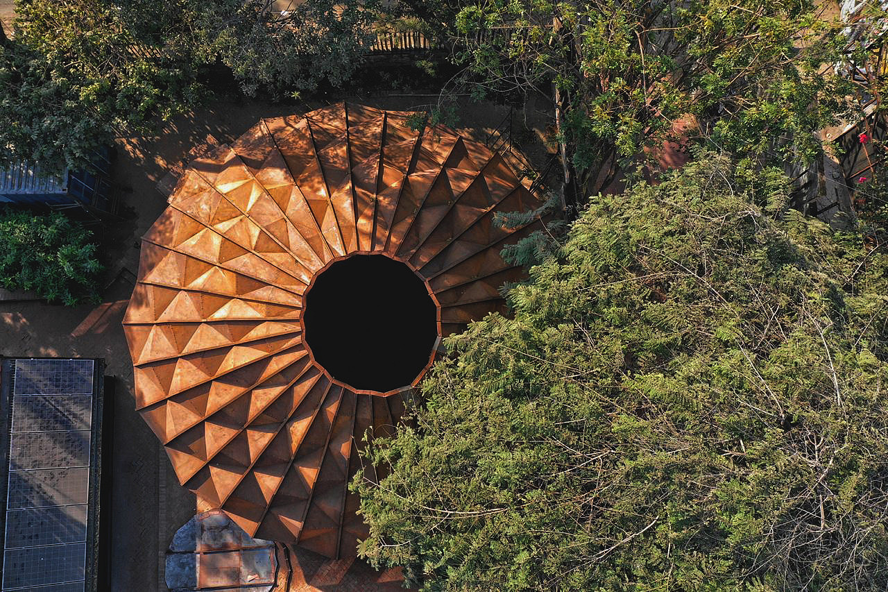 结构
<br><br><br>独特的美学语言是以结构上的诚实为目的而实现的。520立方米的宽敞体积是通过现场组装的独特外壳结构实现的。由1mm厚的折叠金属隔热板组成的扁平包装系统可以在运输集装箱中运输。整个模型中绘制的山脊将结构固定在基座上。构造允许116m²的开放式平面图，而空间的动态轮廓打破了单调。这进一步为居住者提供了独特的空间体验。该结构的屋脊设计用于负荷分配、电线管和环境照明，并采用独特的细木工材料进行防水。门口位于中间山脊的最高点，向外延伸形成一个门槛。砖底座结合了交错的边缘，与金属结构的鲜明本质相得益彰。窗体的下半部分设有窗户，用于空气流通，并设计了一个独特的窗板，可沿其中心轴线枢转；与镶嵌结构无缝对齐。