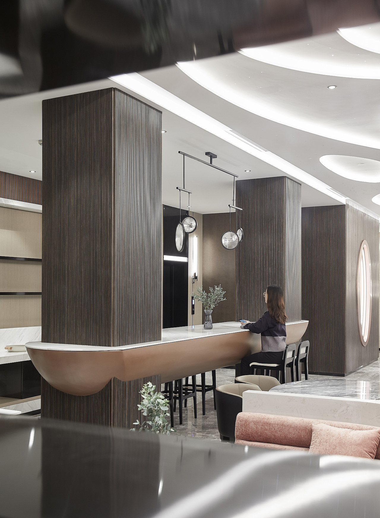 电梯厅立面采用未来感十足的精致线条壁灯，结合轿厢内网络交错的透光烤漆玻璃墙面，来延伸大堂线条感的设计。整体空间用灯光融合了线条的趣味性和视觉性，营造了未来科技感。