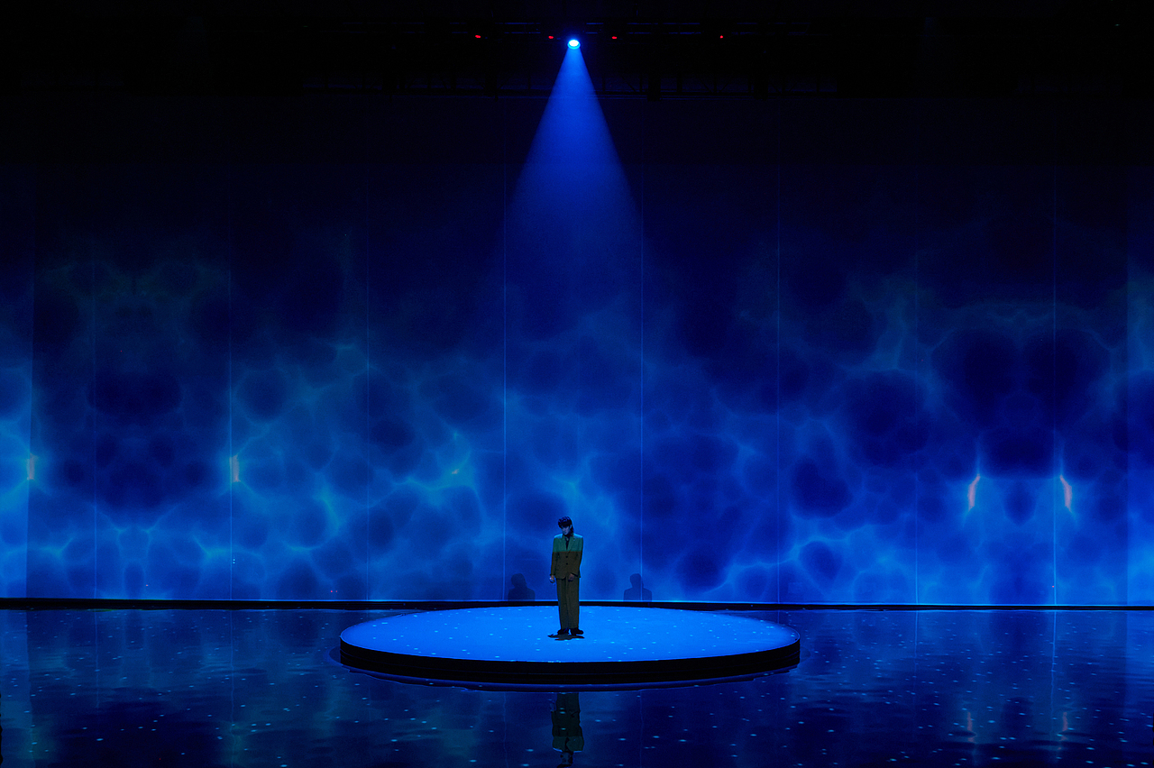 《鱼缸旅馆》充满故事性的歌词和温柔的浅唱,仿佛把我们带入深夜一个孤寂的角落。将水池幻化成巨大的鱼缸,旅馆中常见的各种摆件在水面浮起沉落,背屏纱幕的设计是映射的水光,与波光粼粼的水池相衬。