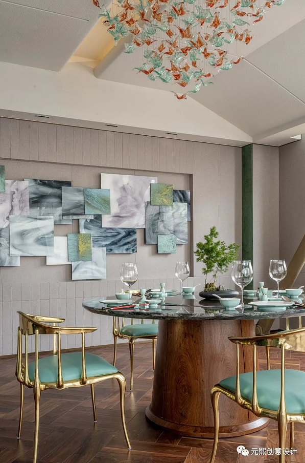雕塑感强烈的天花吊灯,可看作是墙面上艺术品的微妙变体。纺织物触感的墙面,与艺术印花织物座椅,让就餐氛围如家庭般温馨。