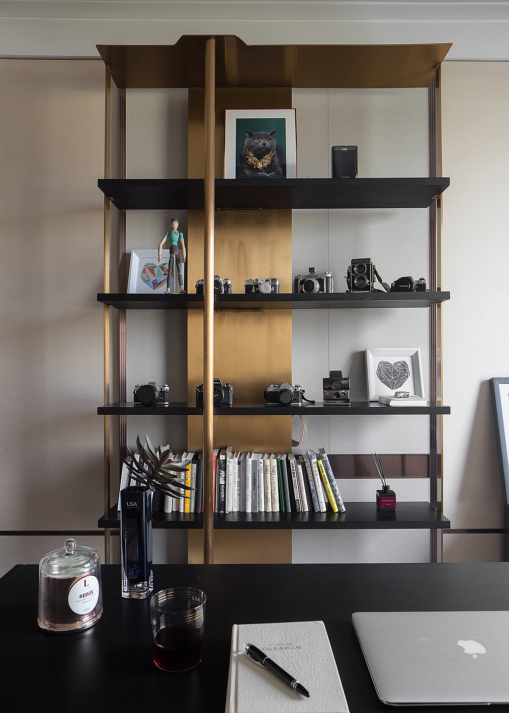 书房的开放式书架由简单的金属结构组成，书架上摆着纪念品和书籍，通过线条和光阴的组合，已然成为一道亮眼的风景线。
