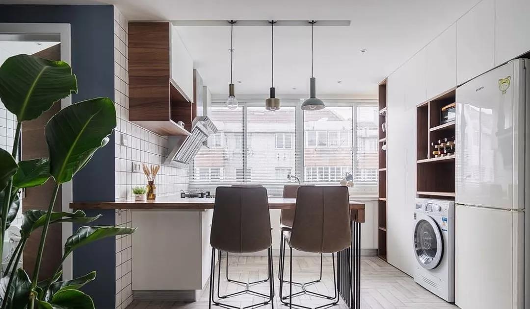 起居、盥洗、餐厅一气呵成,原木的餐桌与厨房台面连为一体,搭配别致的吊灯,营造了温馨的氛围。