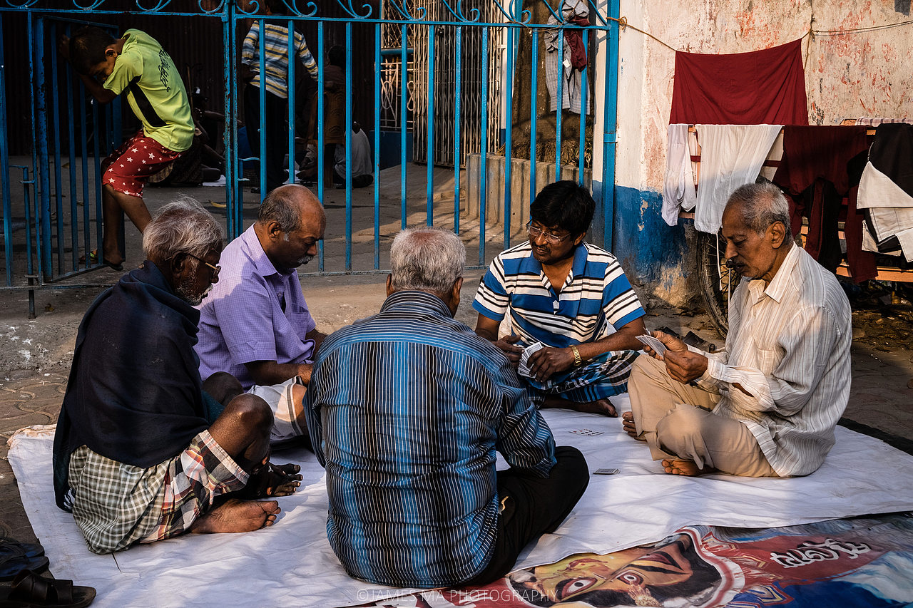 夕阳西下时,老人们打扑克,孩子在门上荡秋千