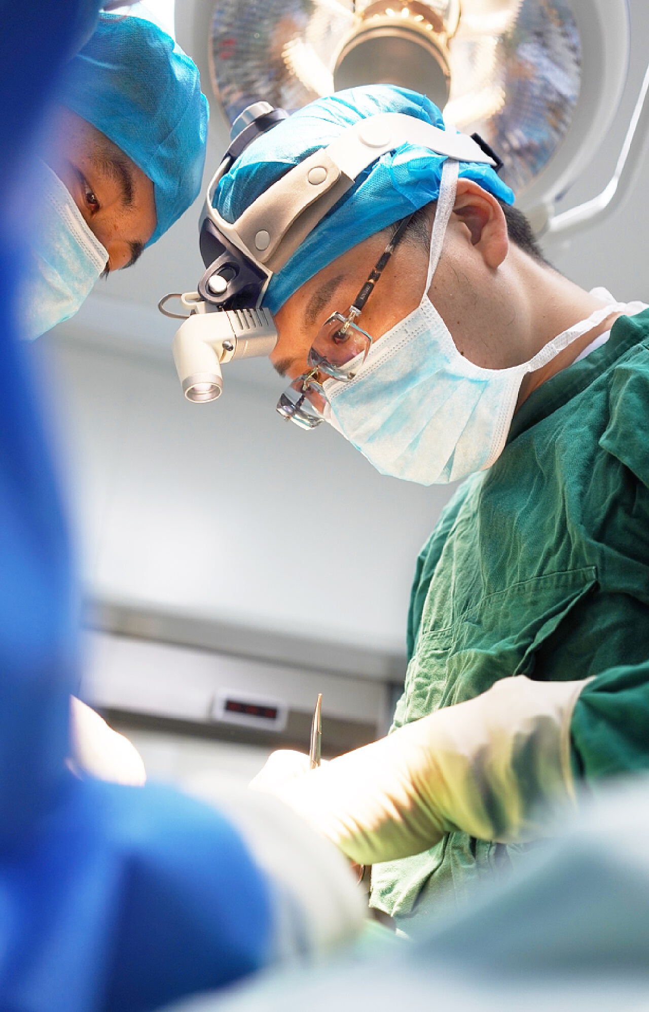 男性外科医生在手术室戴外科手术手套表情专注医疗健康素材设计