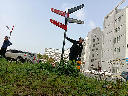 看，一个草根大叔正和指路牌摆pose