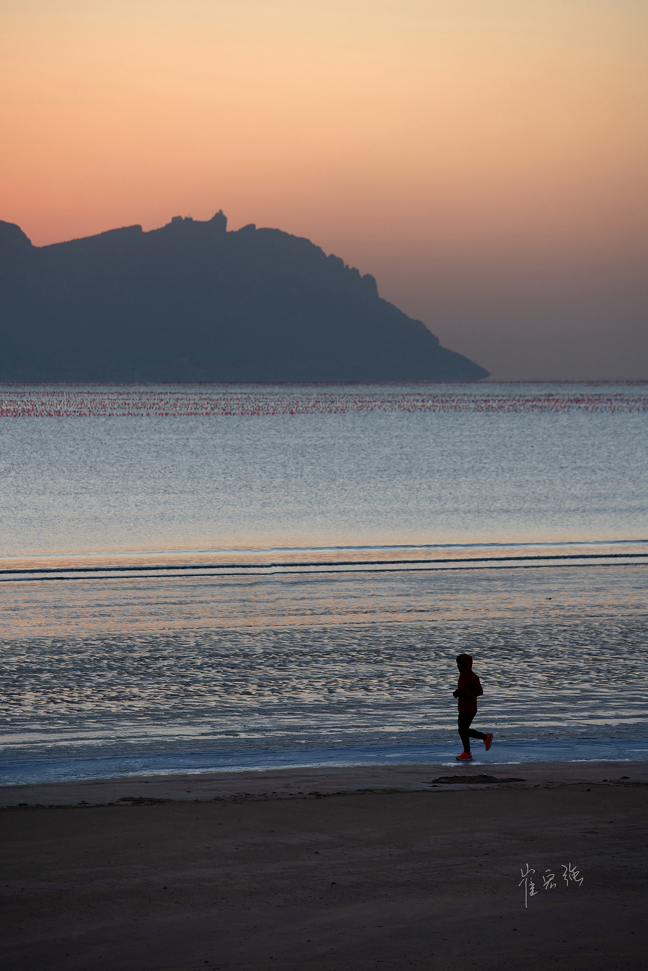 清早5点,太阳从灵山岛背后缓缓升起,一位跑者,沿海边慢跑。