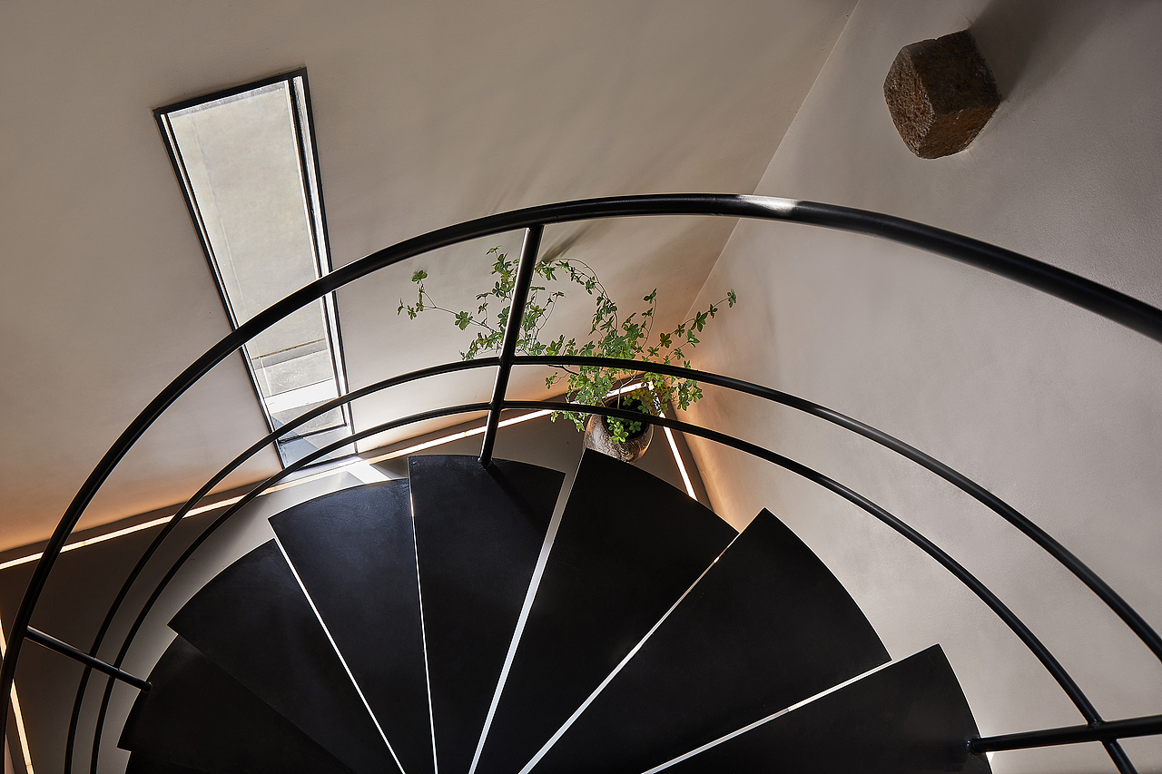 旋转楼梯,以极简的黑色钢板和造型将空间的内耗尽量减少,串联上下层的