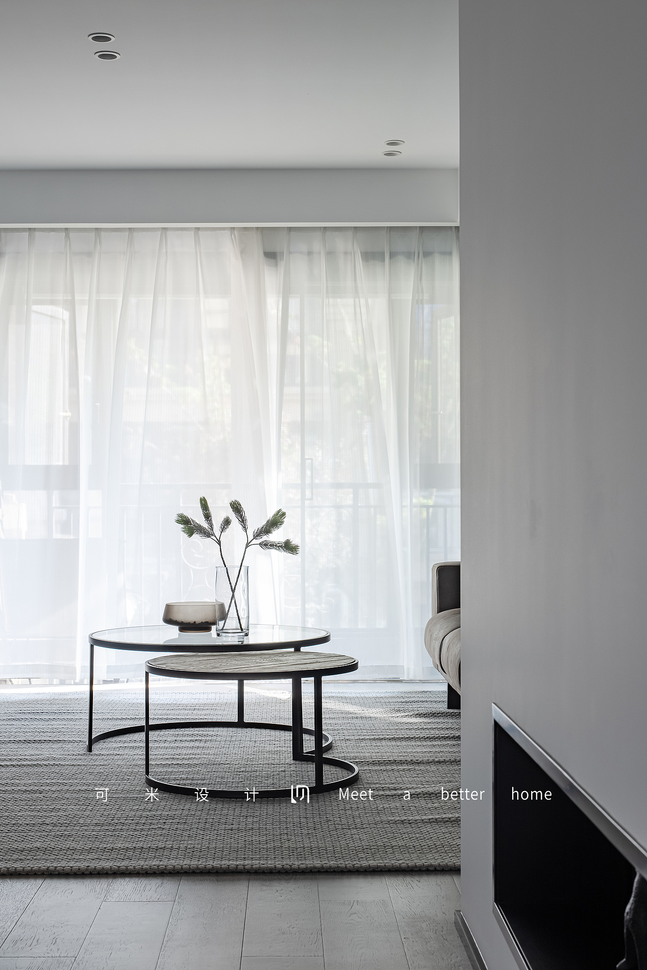 客厅中间放置了组合式的圆形茶几,轻巧便于移动,由透明玻璃、木制、铁艺三种材质组合,沉稳大气;搭配上简约的花瓶与绿植,带来一种和谐的美感,使空间上更加丰富、更有层次感。