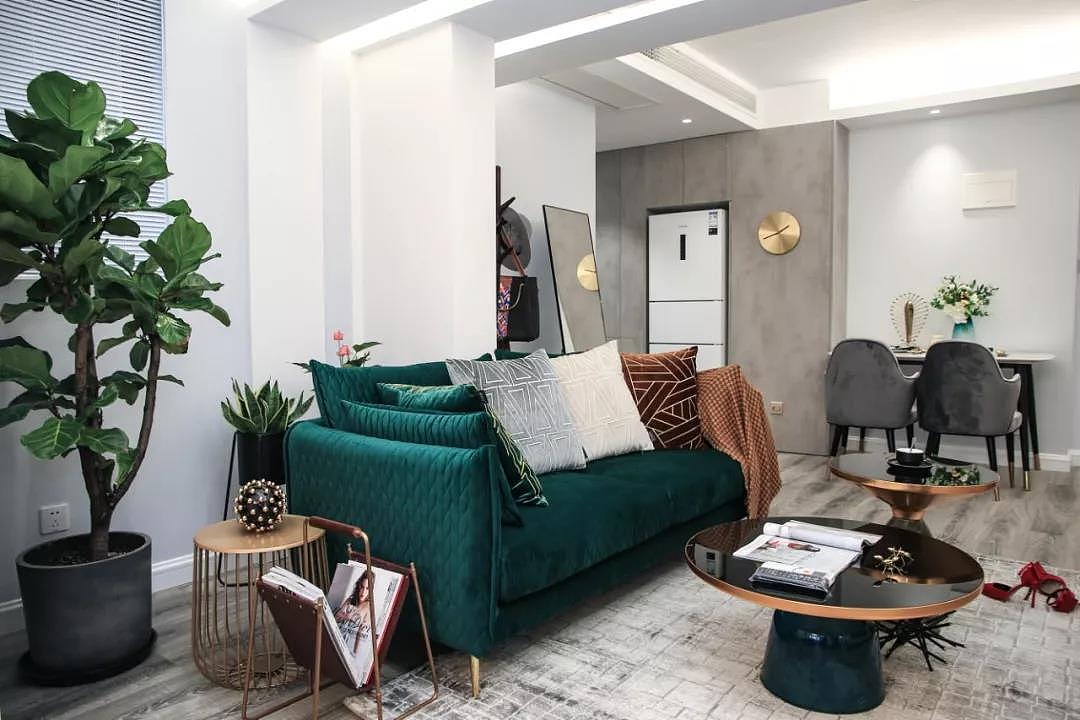 墨绿色的丝绒沙发,搭配金属质感的茶几、边几,营造出精致有质感的轻奢氛围。