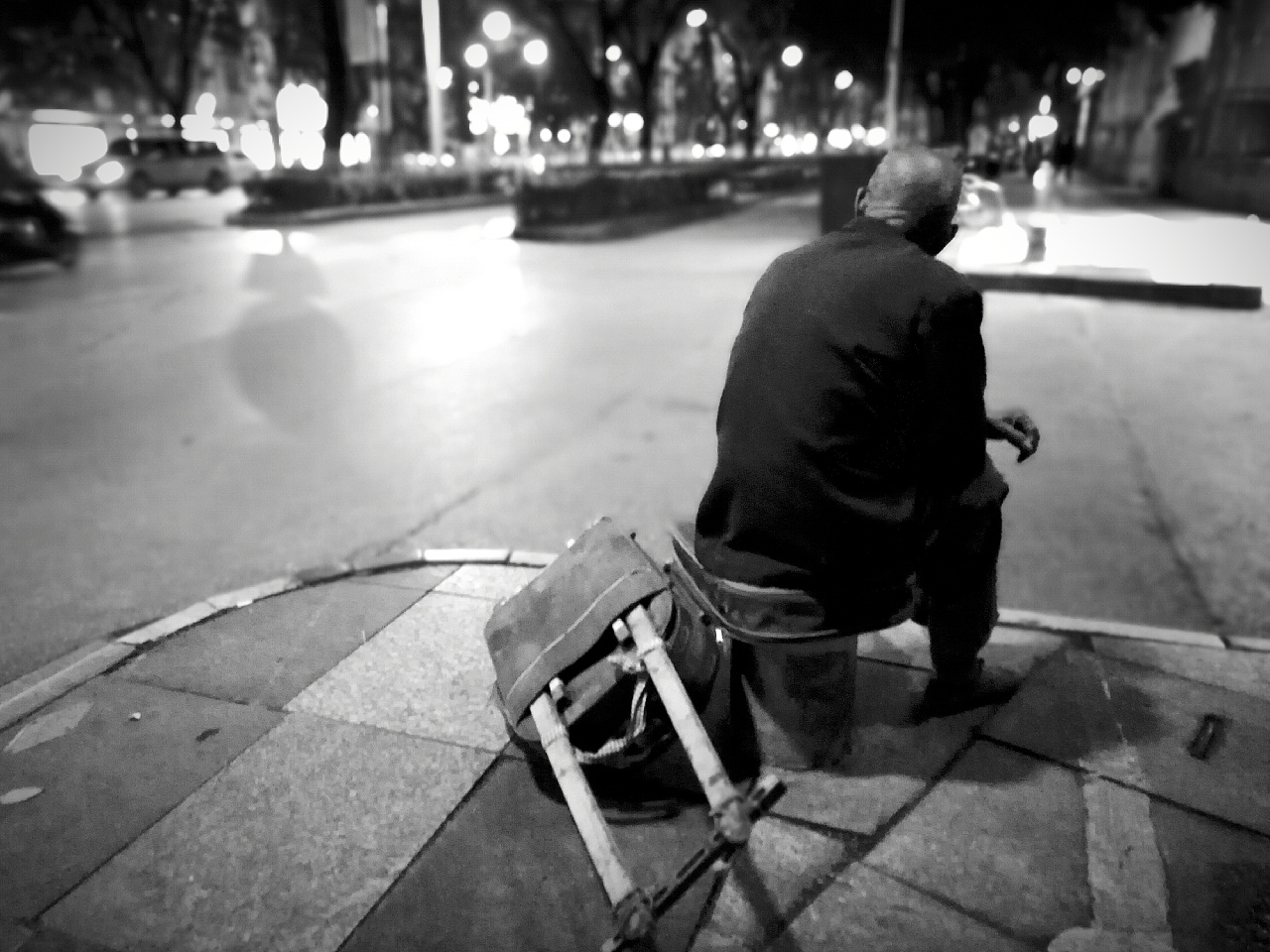 他,静静坐在街头,背影里有无尽的悲伤落寞,眼神游离无助望着前方没有