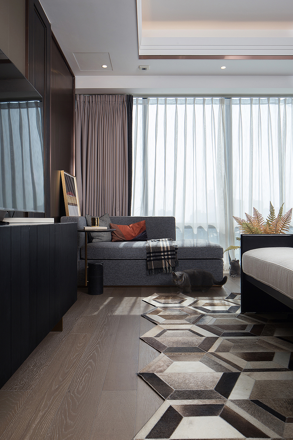 卧室以舒适为主，落地窗提升了空间的舒适度，而窗帘与客厅位置属同色系，互为呼应又相互平衡。特意挑选的几何图形地毯也格外实用，就连家里的两只萌猫也十分钟意呢！