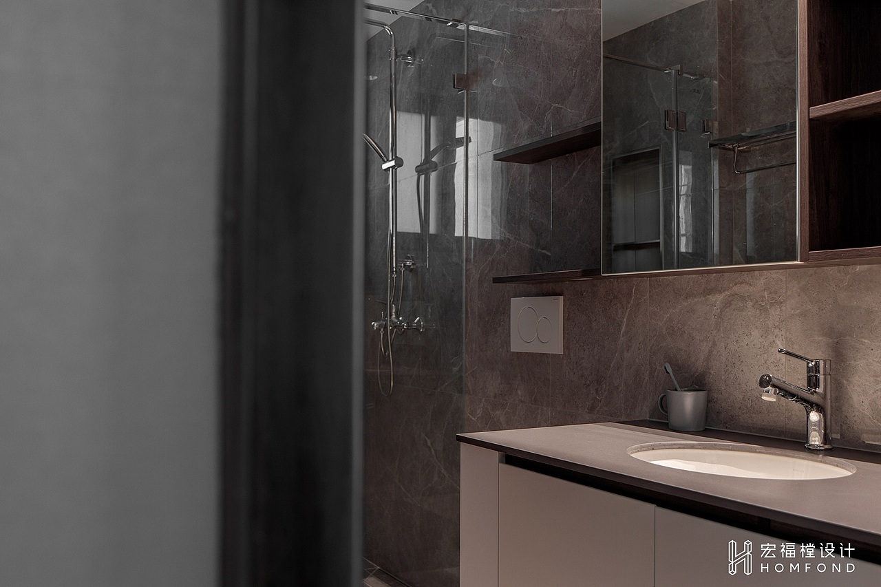 卫生间空间延续了外部的材质，整体以大理石材质上墙，视觉基调更深沉。精致、利落的同时又充满了慵懒、随性的生活感。