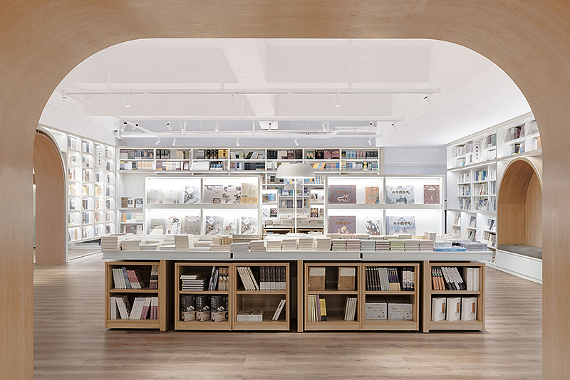 从这个灵感出发,峻佳设计将「桥」的概念进行多元衍生,弧形及桥拱元素设计贯穿门廊、书柜展台及店铺外围空间,巧妙呼应整个空间主题,强调了室内外空间新与旧的交融,表达品牌对城市精神和文化记忆传承。