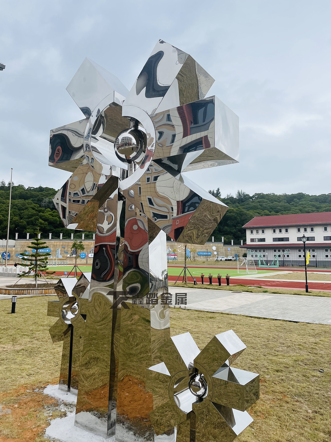 学校镜面不锈钢风车雕塑实景安装、彰显雕塑的气韵