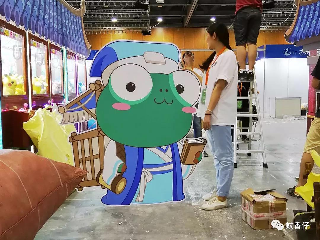 展位设计花絮7：快搭建完毕的时候，我发现我们做的物料好像蛮大块的，就叫小姐姐跟蚊香仔比比身高！瞬间萌到我了！