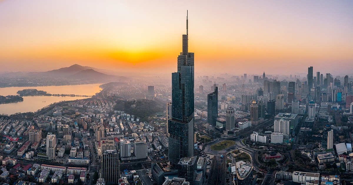日出时的紫峰大厦与远处的玄武湖和紫金山