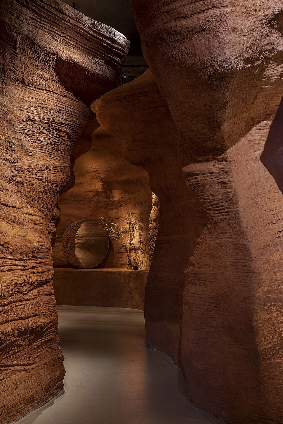“峡谷“力场营造:当人走进场地主入口后首先是一段缓冲空间做为接待区,进门右手边是导台;左手边做为“峡谷”的开启,站在这一端可以看到峡谷另外一端从露台进来的自然光,同时视线的末端会出现椭圆形吧台,吧台上半部分为金属罩被光打亮,远望过去很光滑很现代会引发人继续向前探索的兴趣;