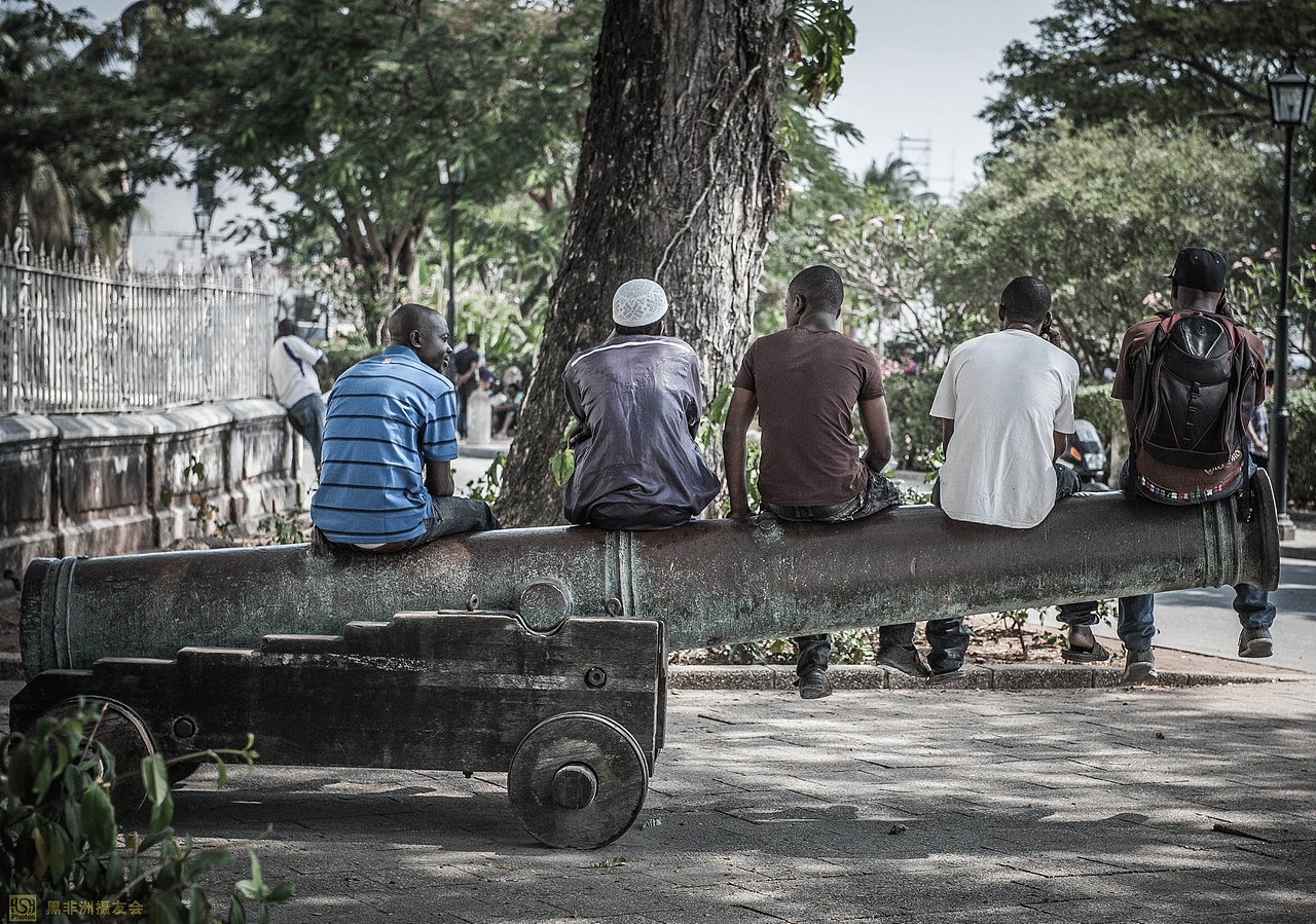 奇迹宫殿门口的大炮上面坐着5个年轻人。