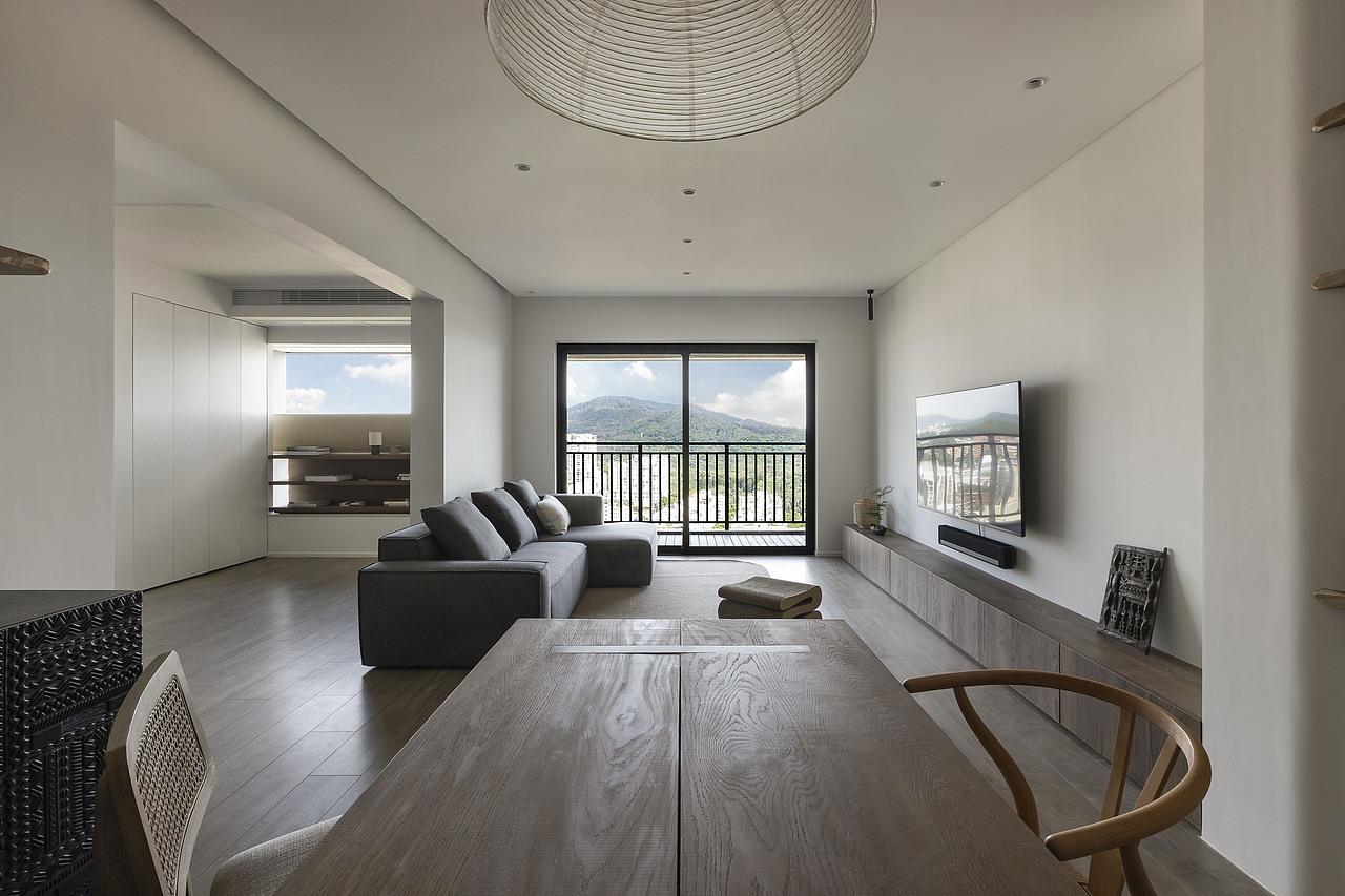 为了让客厅的视线更加开阔通透、特意将空调的出风口安置在多功能房的上方。自然光连同户外的自然景观大面积涌入室内，光线经过平顶的漫反射，让整个家都沉浸在静谧柔和的氛围里。 餐桌宽度800mm，在这里可以就餐、喝茶，聊天，也可以用来临时办公。