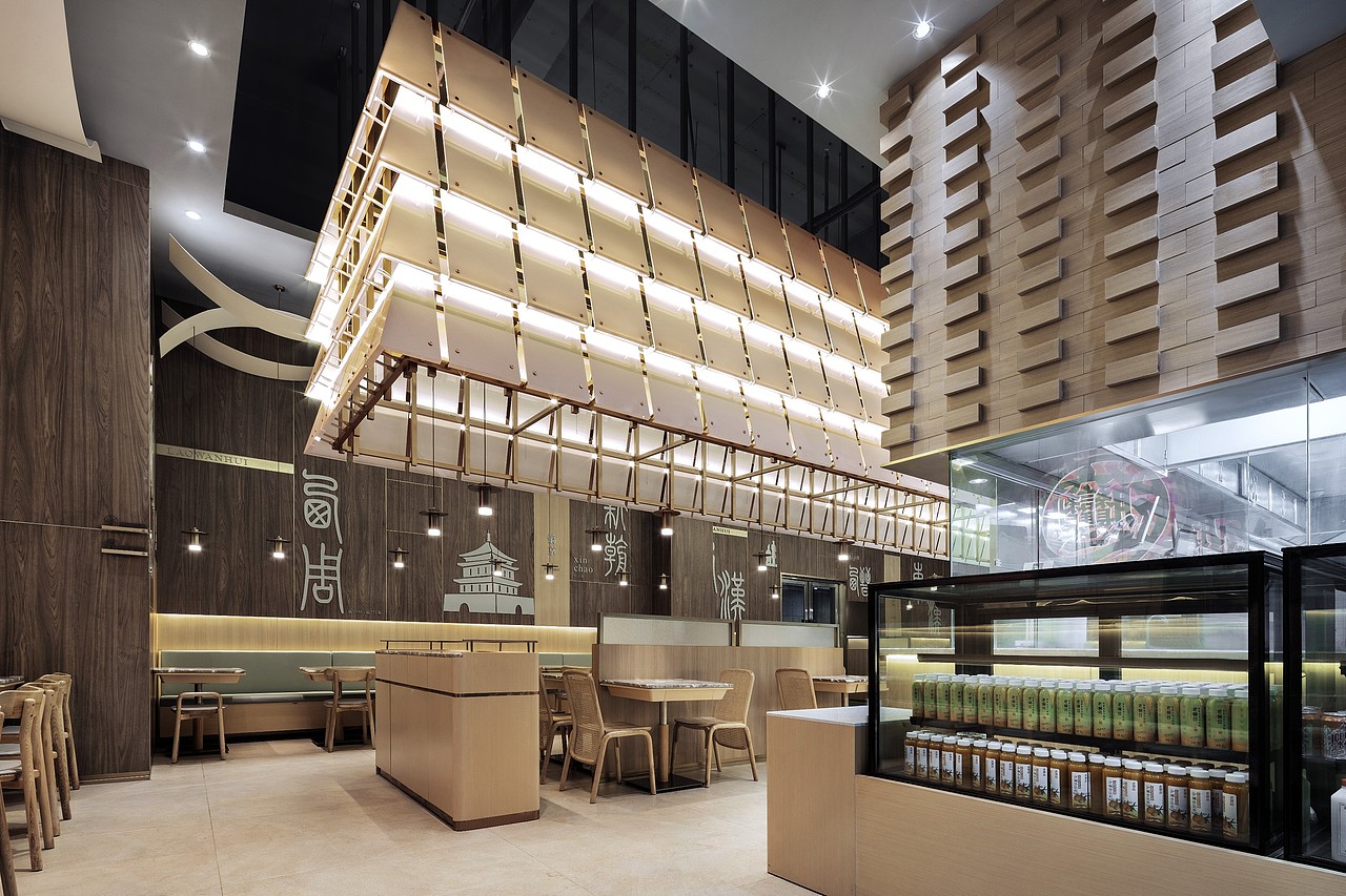 明档上方采用西安城墙的方砖排列，配以凹凸木饰面代替沉重的灰色砖墙，提升了空间的质感和视觉舒适性。
