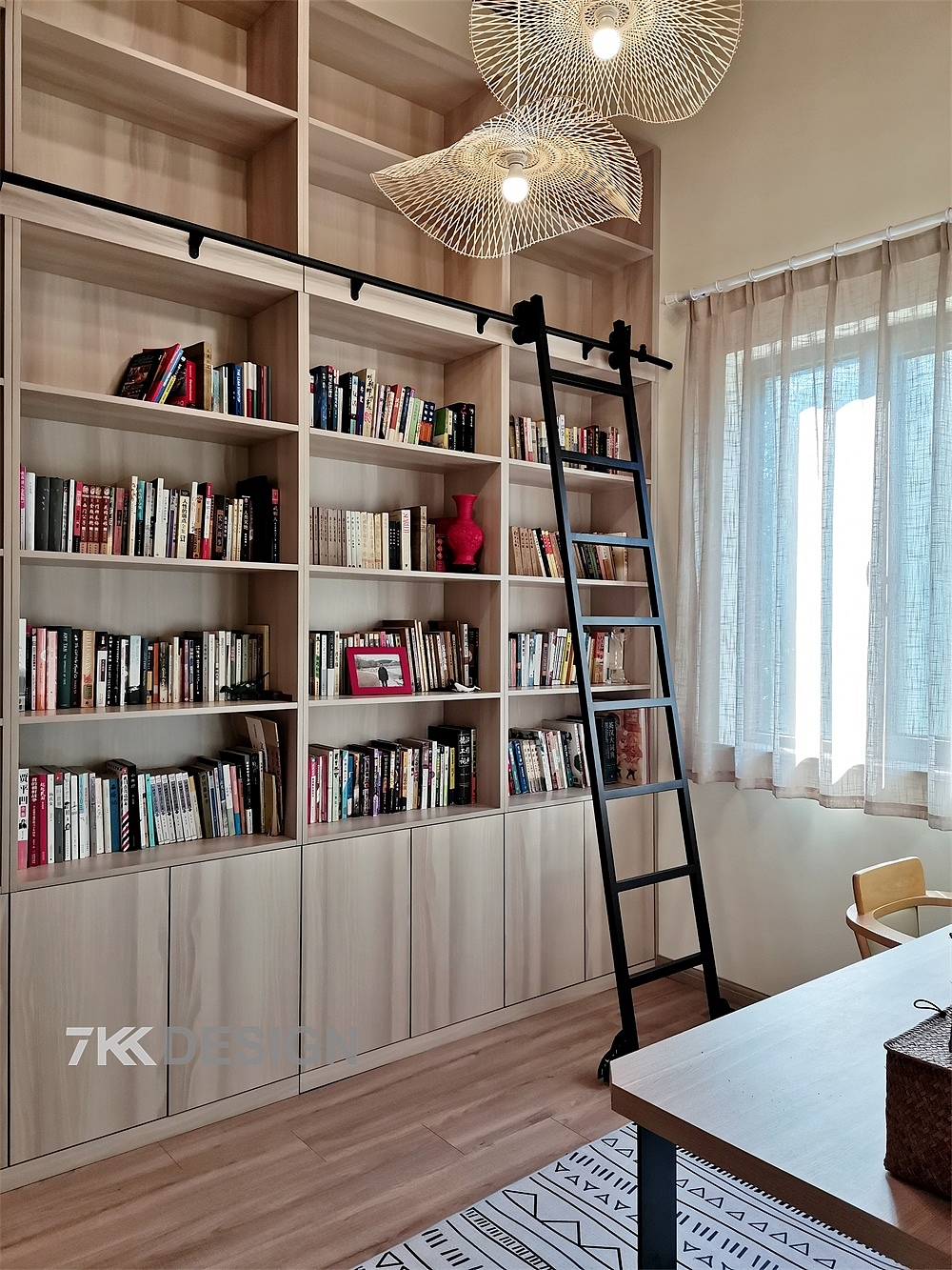 书房空间做了挑空设计，二楼、三楼的高度加起来，层高一共有4.1米。书柜以墙体高度定制，增加使用面积，在柜体三分之二处做滑轨梯子设计，方面业主平时拿取、放置在高处的书籍。