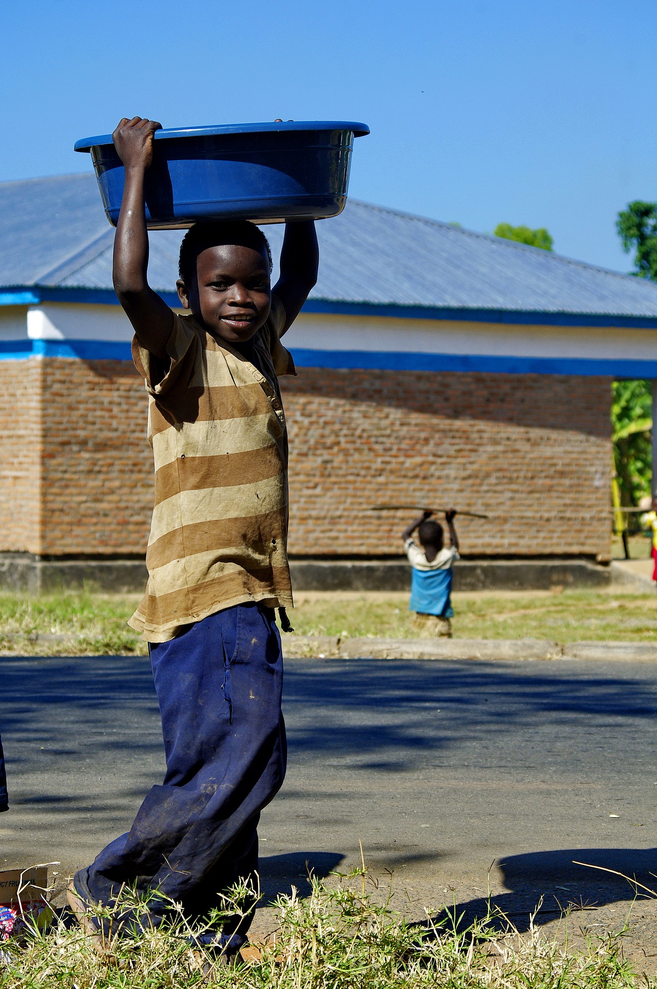 用头来搬运东西,不仅女生如此,男生也如此,这个非洲的小孩子顶了一大