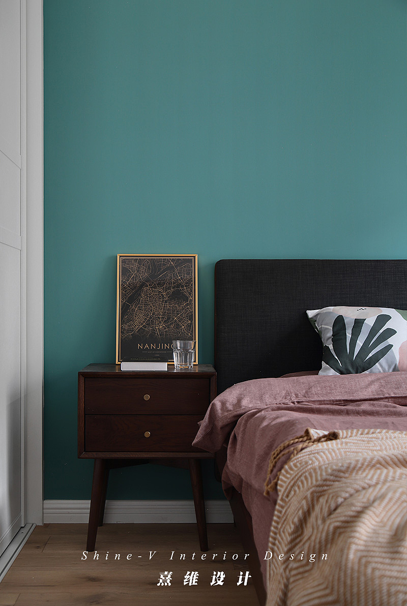 主卧墙面也依然延续着餐厅蓝绿色调,精心挑选的装饰画,柔软的织品与