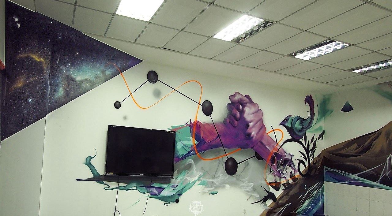 另一间办公室则是一种不同的风格,写实和写意对比呼应。现实的双手和星空的角落则是形成远近的距离,墙角的星空依仗着本身的优势加强深邃的效果,与右边的地球形成一个三维空间。暗示宇宙的多重可能,有待人类的探索。前景的双手象征着有力的合作,也是背景的衬托。